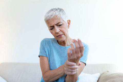 mujer anciana apretándose la mano