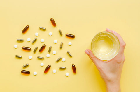 vitaminas y un vaso de agua