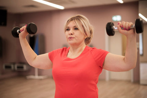 mujer con mancuernas haciendo deporte